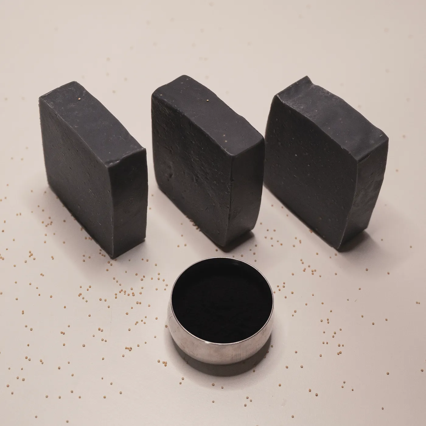 Three bars of Noir charcoal soap standing in a row